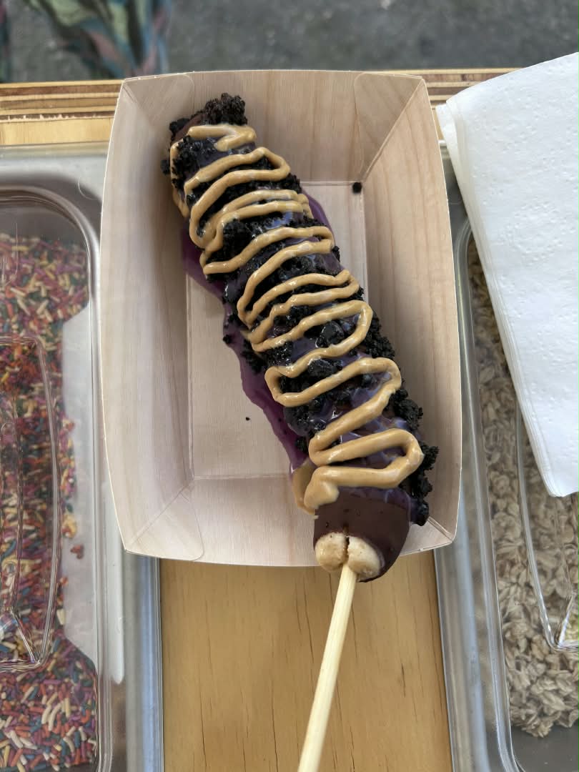 Chocolate-dipped frozen banana with sprinkles on a stick