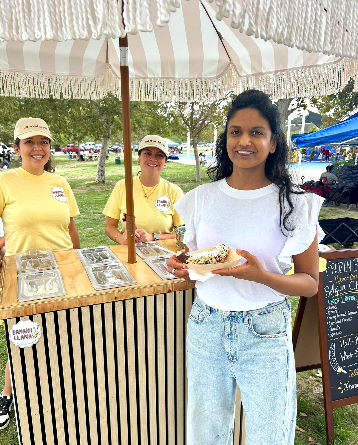 Banana Llama staff serving chocolate-dipped bananas at full-service event
